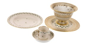 Posliinisen astiastot osia: lautanen, leipäkori sekä pieni kuppi tassilla.
