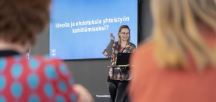 Henkilön taustalla diassa teksti: Ideoita ja ehdotuksia yhteistyön kehittämiseksi?